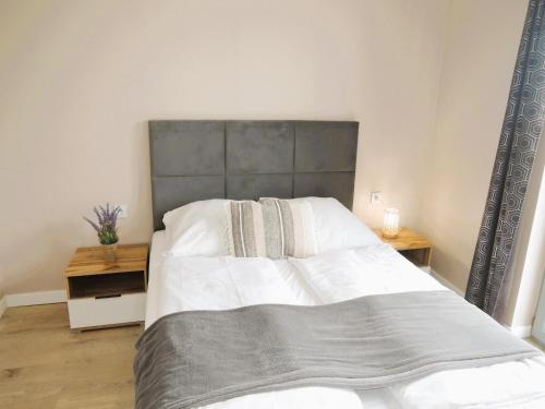 a bedroom with a large bed with a gray headboard at Luxury holiday home for 20 people in Kołczewo