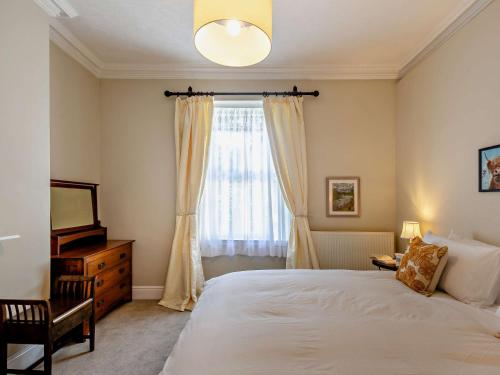 Un dormitorio con una cama grande y una ventana. en 1 Bed in PENMAENMAWR 95495, en Penmaen-mawr