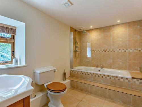 a bathroom with a toilet and a sink and a tub at 1 Bed in Bampton 94766 in Bampton