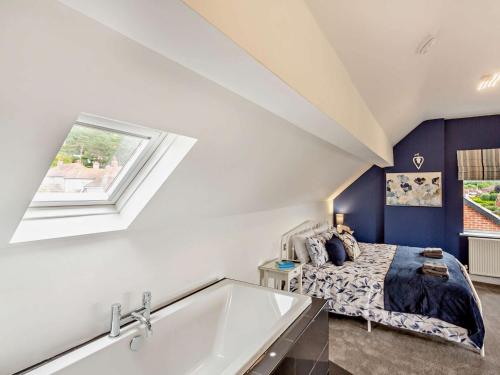 a bedroom with a bed and a tub and a window at 4 Bed in Llandudno 95235 in Llandudno