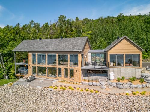 a home with a large house with windows at La Bergerie in Saint-Joseph-de-la-Rive