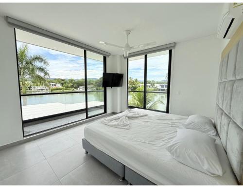 a bedroom with a bed and a large window at Casa con piscina y BBQ en Lagos del Peñón Girardot in Girardot