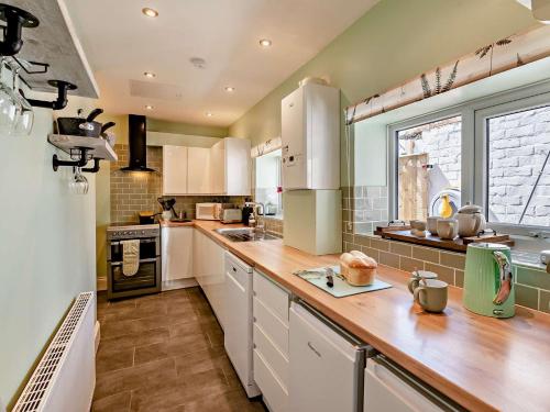 a kitchen with white cabinets and a wooden counter top at 2 Bed in Helmsley 96097 in Helmsley