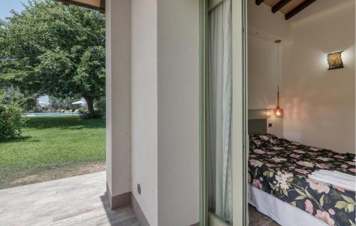 a bedroom with a bed and a view of a yard at Nice Home In Montalto Di Castro in Montalto di Castro