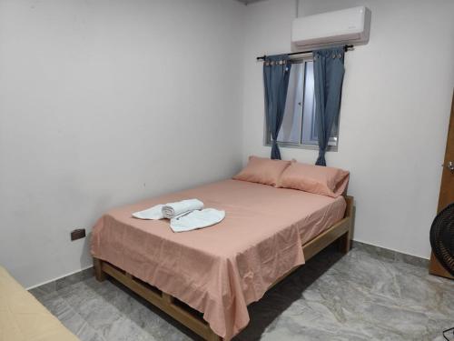 a small bedroom with a bed with two towels on it at Habitaciones con wifi a 5 minutos de la playa in Capurganá