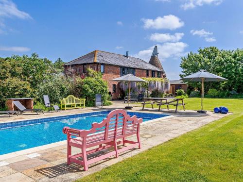 a pool with a red bench next to a house at 5 Bed in Smarden 76428 in Smarden