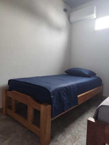 a bed in a room with a blue bedspread on it at Habitaciones con wifi a 5 minutos de la playa in Capurganá