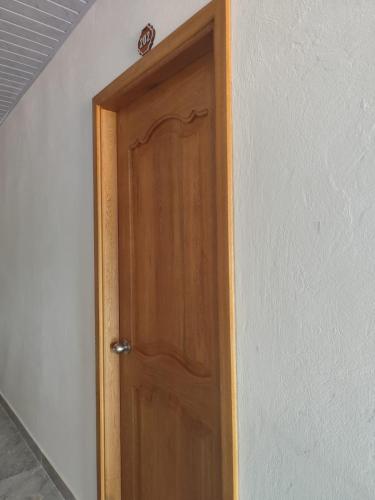 a wooden door in a room with a wall at Habitaciones con wifi a 5 minutos de la playa in Capurganá