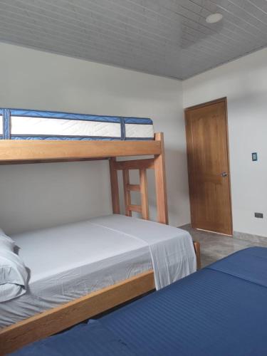 a bedroom with two bunk beds and a door at Habitaciones con wifi a 5 minutos de la playa in Capurganá