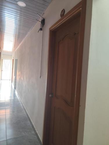 a hallway with a wooden door in a room at Habitaciones con wifi a 5 minutos de la playa in Capurganá