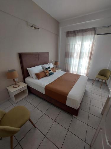 a bedroom with a large bed and a chair at Maria Studios in Paleokastritsa