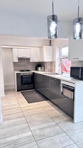 a kitchen with stainless steel appliances and white cabinets at Luxproperties in Birmingham