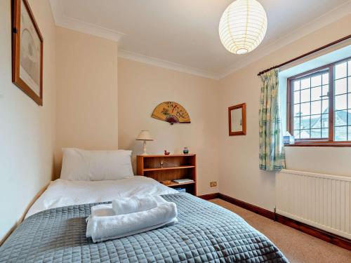 a bedroom with a bed and a window at 5 Bed in Lower Slaughter 94643 in Lower Slaughter