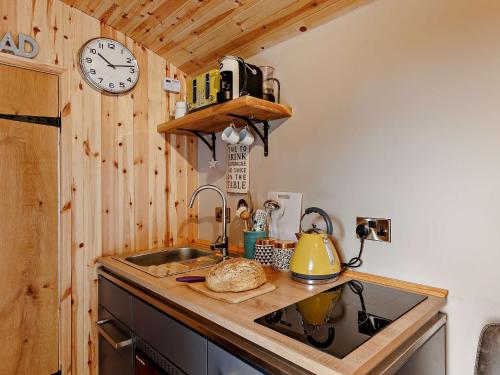 a kitchen with a sink and a clock on the wall at 1 Bed in Welshpool 92796 in Welshpool