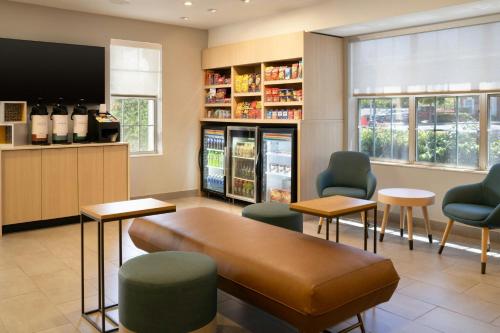 a waiting room with a couch and chairs and a tv at TownePlace Suites Milpitas Silicon Valley in Milpitas