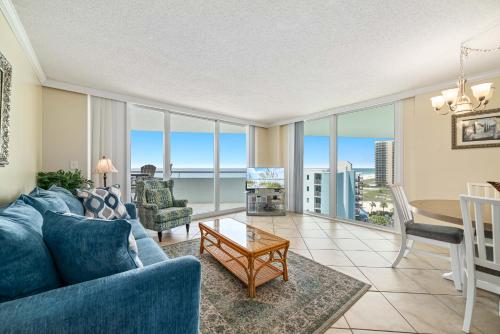 a living room with a blue couch and a table at Perdido Sun Unit 914 in Pensacola