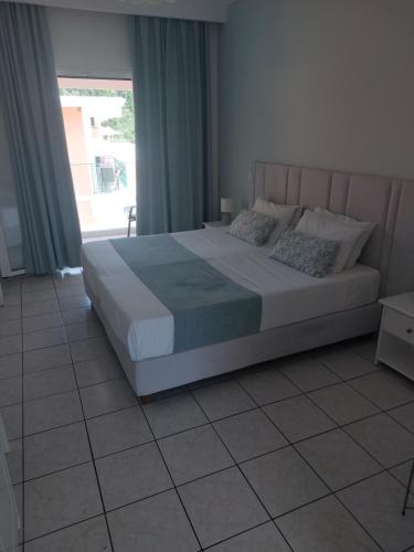 a large bed in a bedroom with a window at Maria Studios in Paleokastritsa