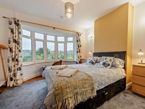 a bedroom with a bed and a large window at 4 Bed in Wisemans Bridge 57793 in Amroth