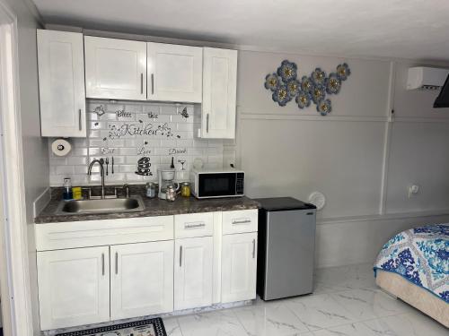 a kitchen with white cabinets and a sink and a refrigerator at Time to relax in Tampa
