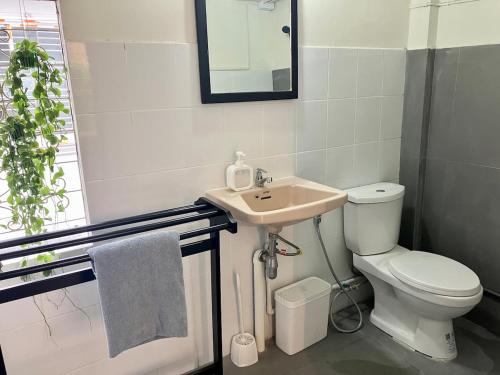 a bathroom with a white toilet and a sink at Bali Style Rooftop Apartment in Bangkok