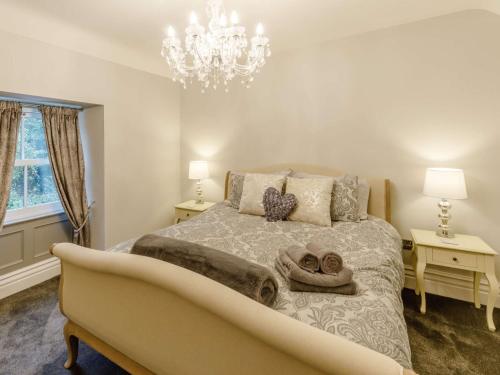 a bedroom with a bed and a chandelier at 4 Bed in Cromford 82198 in Cromford