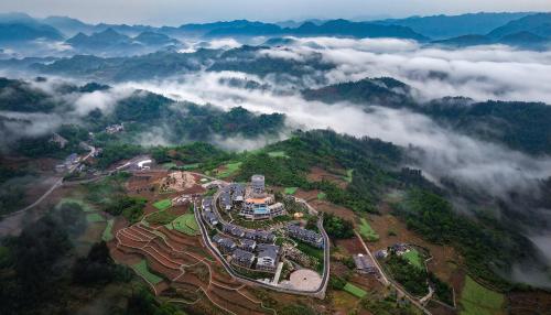an aerial view of a mountain in the clouds at Valley Secret Resort in Zhangjiajie