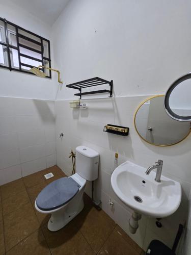 a bathroom with a toilet and a sink at Homestay DAR AL - HAQEM Full Aircond in Kuantan