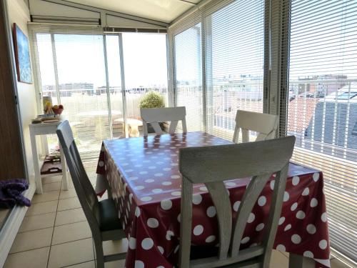d'une table à manger avec un chiffon de polka. dans l'établissement T2 avec Wifi, grande terrasse exposée sud, à 500m de la plage - FR-1-92-924, à Les Sables-dʼOlonne
