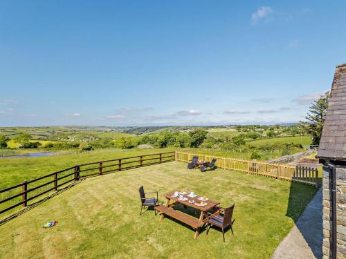 a patio with a table and chairs on the grass at 4 Bed in Aberaeron 92072 in Llanrhystyd