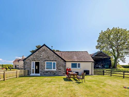 a stone house with a picnic table in the yard at 4 Bed in Aberaeron 92072 in Llanrhystyd