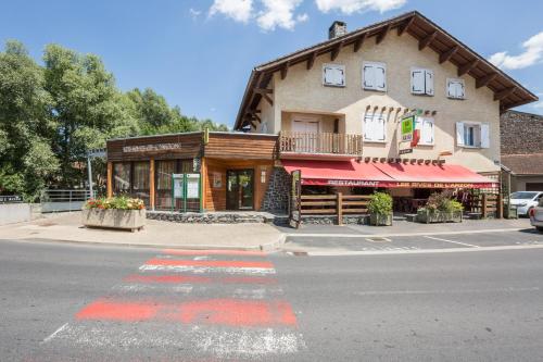 a building on the corner of a street at Logis Hotel Restaurant Auberge Les Rives de l'Arzon in Vorey