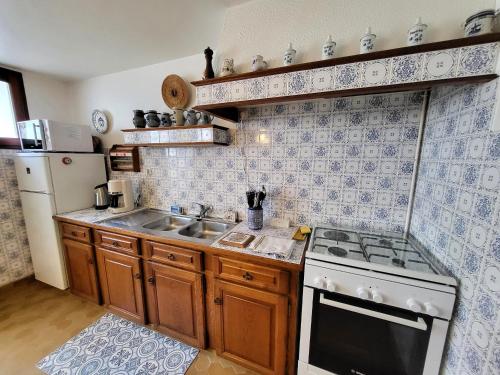 Il comprend une petite cuisine équipée d'une cuisinière et d'un évier. dans l'établissement Maison 3 ch, cour privée et Wi-Fi, proche plage et commerces - FR-1-92-949, à Les Sables-dʼOlonne