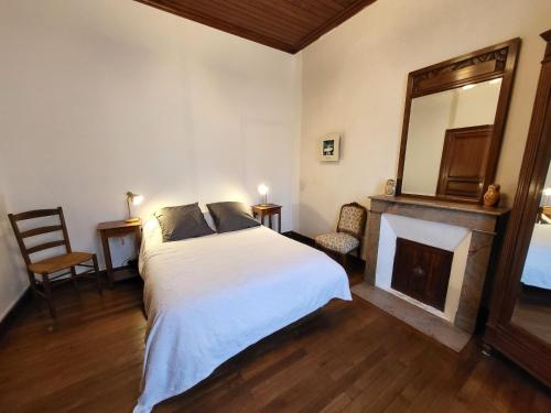 - une chambre avec un lit, une cheminée et un miroir dans l'établissement Maison 3 ch, cour privée et Wi-Fi, proche plage et commerces - FR-1-92-949, à Les Sables-dʼOlonne