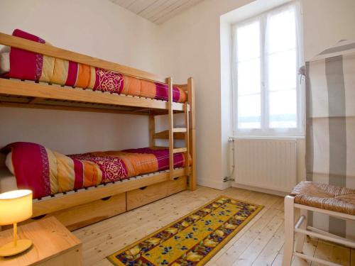 une chambre avec deux lits superposés et une fenêtre dans l'établissement Maison de pêcheur typique à 400m du quai, proche plage, animaux bienvenus, WiFi en option - FR-1-92-671, à Les Sables-dʼOlonne