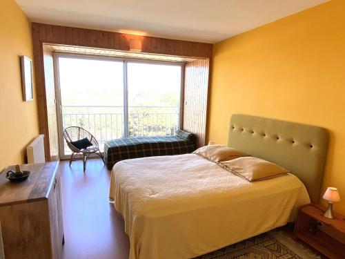 Un dormitorio con una cama y una ventana grande. en Appartement T2 proche plage avec loggia et un animal admis - FR-1-92-649, en La Pironnière