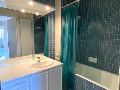 Un baño con lavabo, espejo y bañera. en Appartement T2 proche plage avec loggia et un animal admis - FR-1-92-649, en La Pironnière