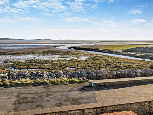 a group of sheep in a field next to a river at 2 Bed in Haverigg 94052 in Haverigg