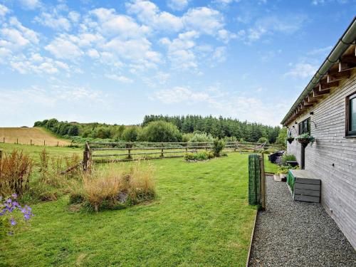 a house with a grass yard next to a fence at 2 Bed in Llandrindod Wells 53193 in Llandrindod Wells