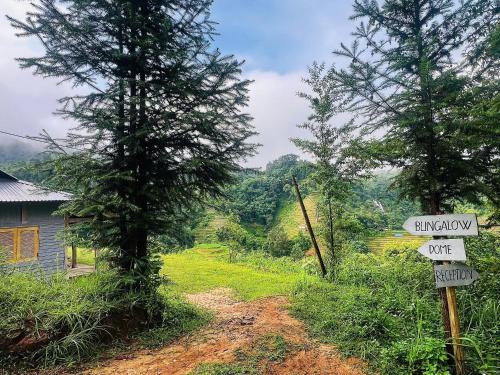 a dirt road with street signs next to a house at Nậm Lỳ Retreat in Ha Giang