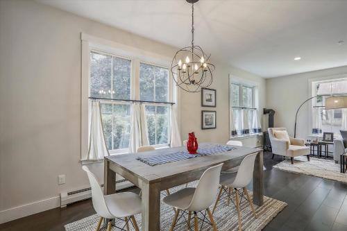 a dining room with a table and white chairs at Scharkie Ski Haus in Stowe