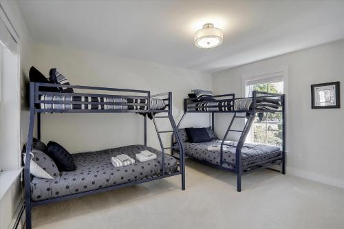 two bunk beds in a room with a window at Scharkie Ski Haus in Stowe