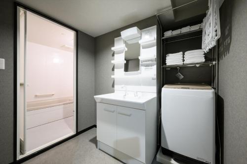 a kitchen with a white refrigerator and a mirror at 廣島別邸 デラックススイート Hiroshima Villa for 10ppl - Supported by COCOSTAY in Hiroshima
