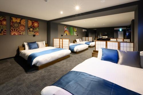 a hotel room with four beds in a row at 廣島別邸 デラックススイート Hiroshima Villa for 10ppl - Supported by COCOSTAY in Hiroshima
