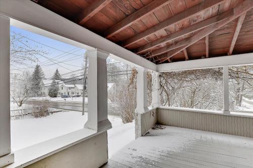 an empty porch with snow on the ground at The Cozy Villager in Stowe
