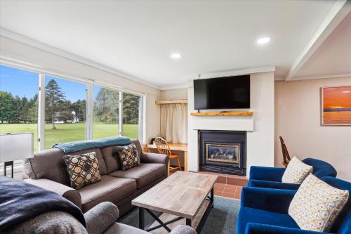 Una sala de estar con un sofá y una chimenea. en Village Green 10C, en Stowe