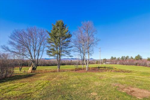 a field with two trees and a wooden fence at Sterling Ridge View in Stowe