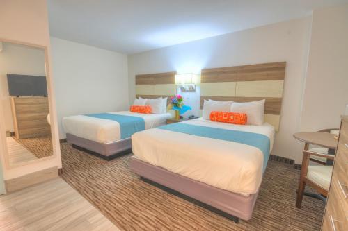 una habitación de hotel con dos camas y una mesa en Monte Carlo Boardwalk / Oceanfront Ocean City, en Ocean City