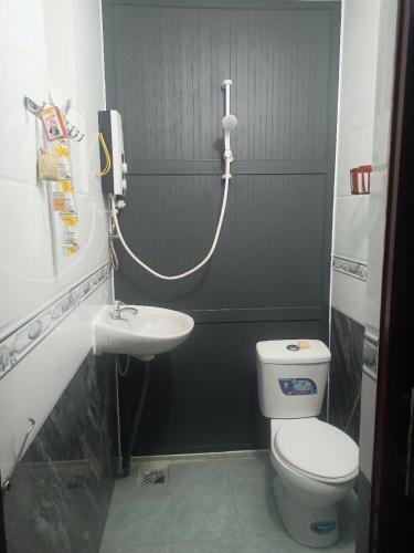 a bathroom with a white toilet and a sink at Hiwinwin Homestay Holiday in Chợ Phước Hải