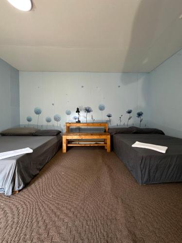 two beds in a room with trees on the wall at Thessalon Heritage Nook on Hghwy 17- Space Share in Thessalon