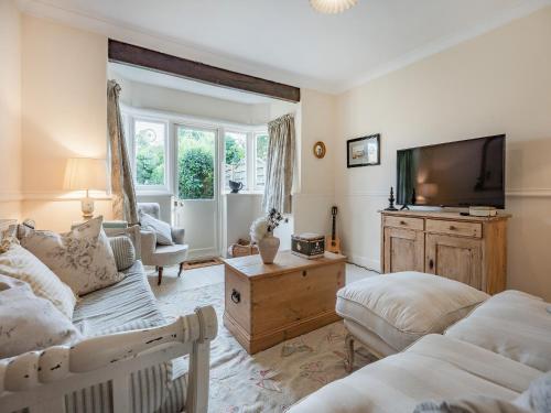 a living room with a couch and a tv at Greenfield Cottage 1866 in Broadwater